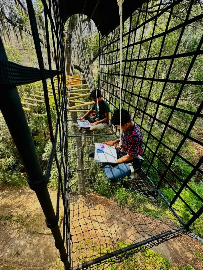 Niños leyendo en puente colgante